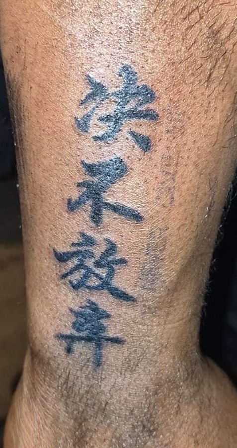 Chinese lettering tattoo on back forearm