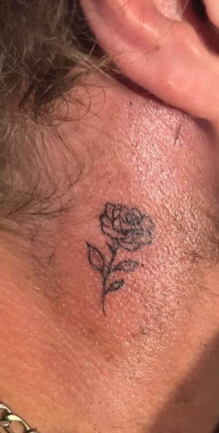 Fine-line rose tattoo on neck
