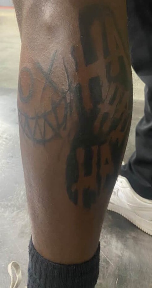 Bold HAHA and smile tattoo on calf