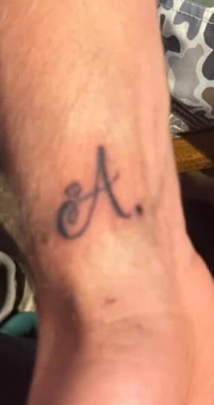 Cursive letter A tattoo on wrist